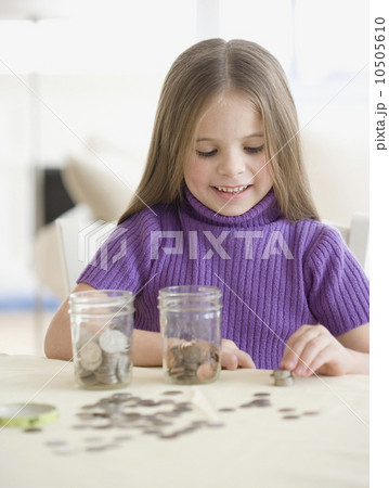 Girl counting and sorting change 10505610