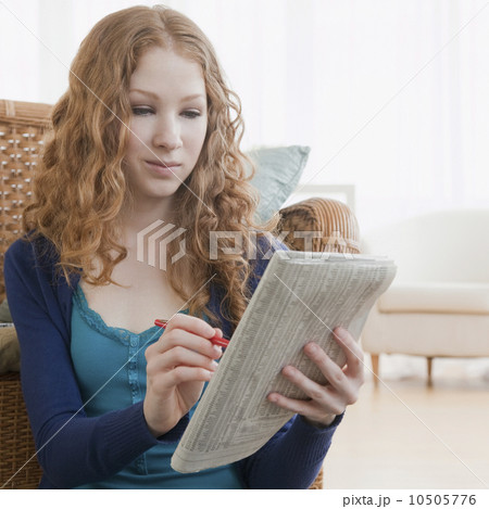 Woman reading ads in paper 10505776