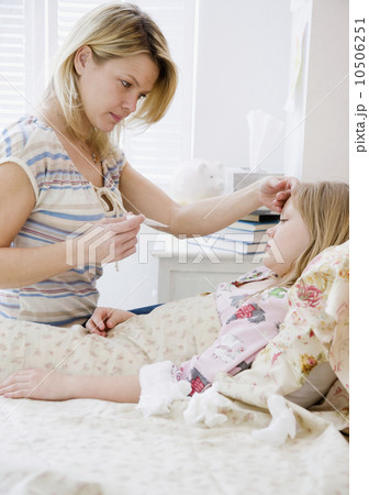 Mother checking daughter’s temperature Mother checking daughter’s temperature 10506251