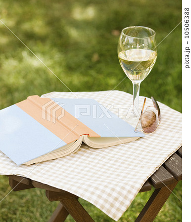 Wine glass and book on outdoor table 10506388