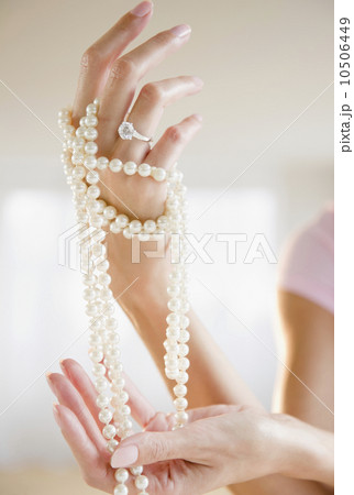 USA, New Jersey, Jersey City, Woman's hand  holding pearl beads 10506449