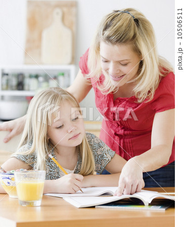 Mother helping daughter with homework 10506511