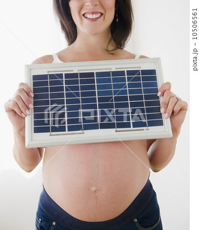Young pregnant woman holding solar panel Young pregnant woman holding solar panel 10506561