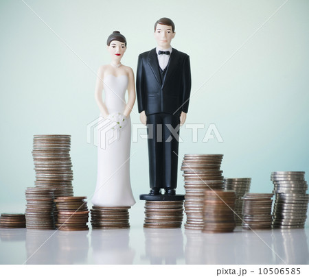 Close up of wedding cake figurines on stacks of coins 10506585