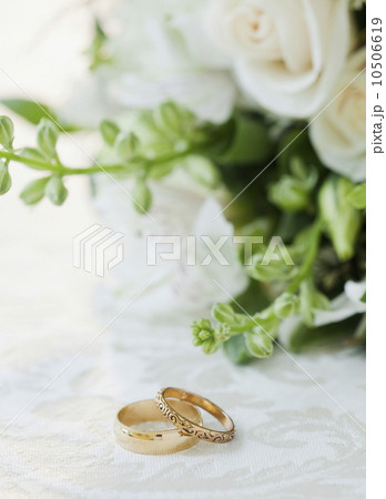 Two wedding rings by bouquet of flowers, studio shot Two wedding rings by bouquet of flowers, studio shot 10506619