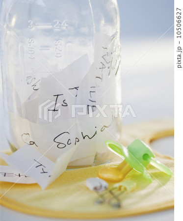 A baby bottle full of baby names beside a pacifier 10506627
