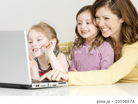 Mother and daughters looking at laptop Mother and daughters looking at laptop 10506678