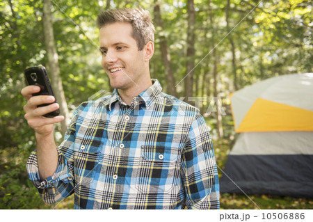 Man using cell phone in forest 10506886