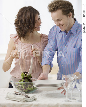 Couple setting table and tossing salad 10506887