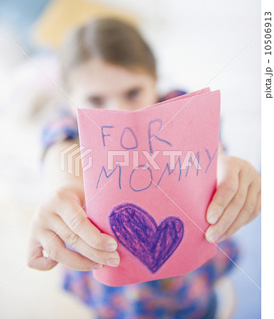 Girl ( 6-7) showing greeting card for mother's day Girl ( 6-7) showing greeting card for mother's day 10506913