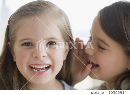 Close up of sisters telling secret Close up of sisters telling secret 10506914