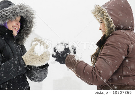 Two young women having snowball flight  10507869