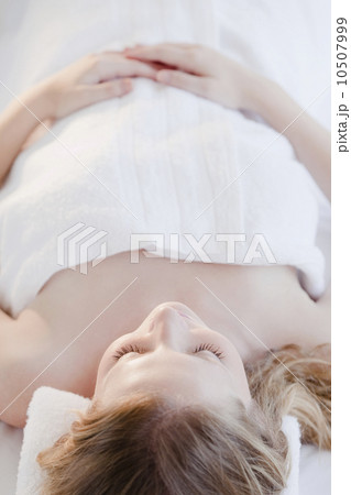 Young woman lying wrapped in towel 10507999