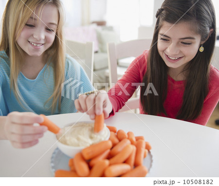 Two girls eating carrots 10508182