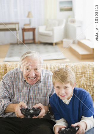 Grandfather and grandson (8-9) playing video games 10508215