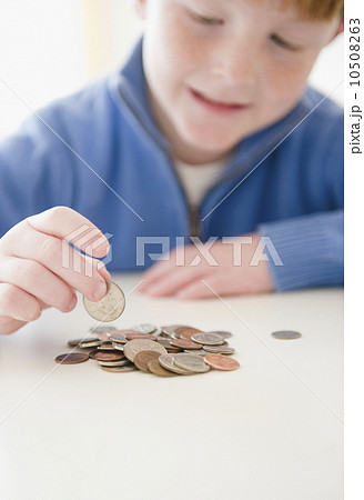 Portrait of boy (8-9) counting coins 10508263
