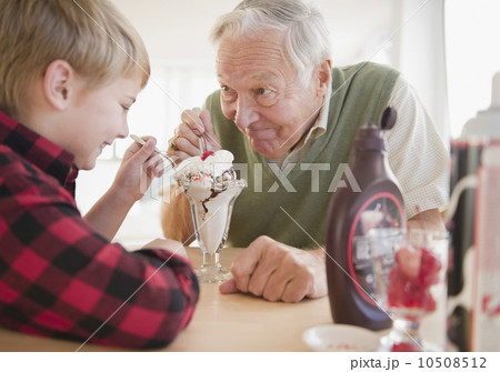 Grandfather and grandson (8-9) eating ice cream 10508512