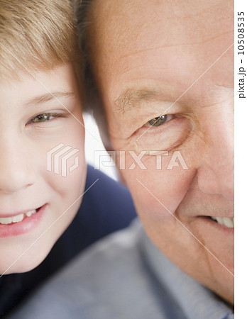 Close up of smiling faces of grandfather and grandson (8-9)  10508535