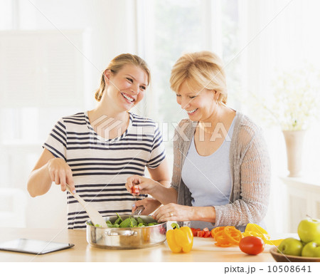 Mother and adult daughter cooking together 10508641