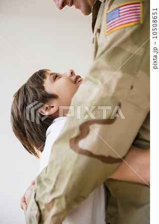 Son (8-9) embracing father 10508651