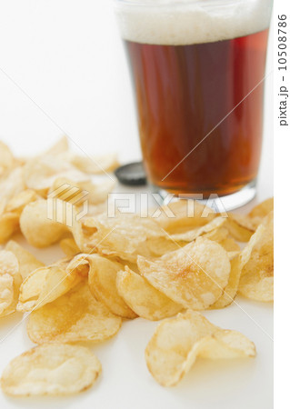 Close up of potato chips and glass of beer, studio shot Close up of potato chips and glass of beer, studio shot 10508786