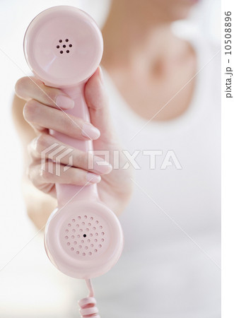 USA, New Jersey, Jersey City, Woman's hand holding pink telephone receiver 10508896