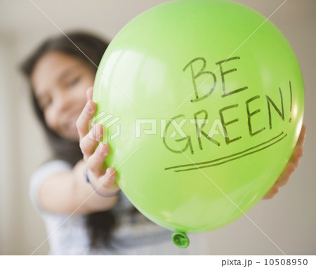 Close up of girl (10-11) with green balloon Close up of girl (10-11) with green balloon 10508950