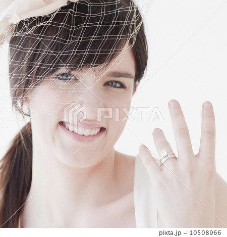Portrait of bride wearing wedding dress, showing ring Portrait of bride wearing wedding dress, showing ring 10508966