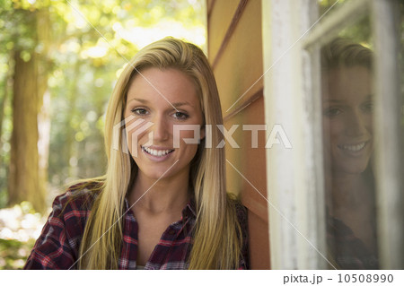 Portrait of young woman standing in front of house 10508990
