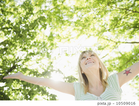 USA, New York, Williamsburg, Brooklyn, Portrait of smiling woman under green tree 10509016