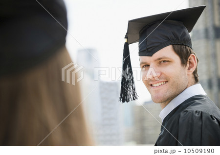 Young man and woman wearing graduation gowns 10509190