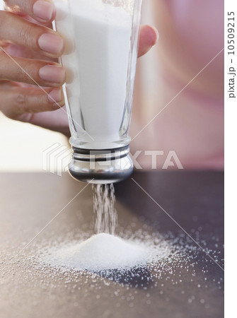 USA, New Jersey, Jersey City, Woman hand holding salt shaker upside down 10509215