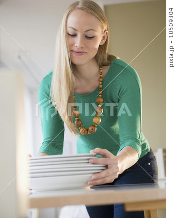 Young woman setting table Young woman setting table 10509304