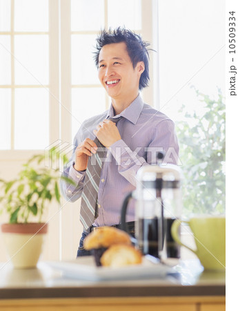 Teenage boy (16-17) tying tie Teenage boy (16-17) tying tie 10509334