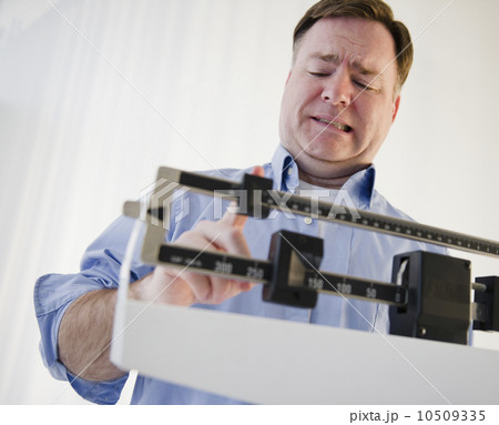 USA, Jersey City, New Jersey, man on weight scales USA, Jersey City, New Jersey, man on weight scales 10509335