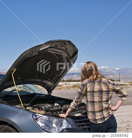 USA, California, Palm Springs, Woman standing in front of broken car in desert USA, California, Palm Springs, Woman standing in front of broken car in desert 10509592