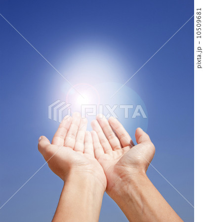 Close up of woman's hands holding sunlight on blue sky 10509681