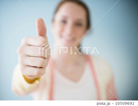 Teenage girl (14-15) showing thumb up, studio shot 10509692