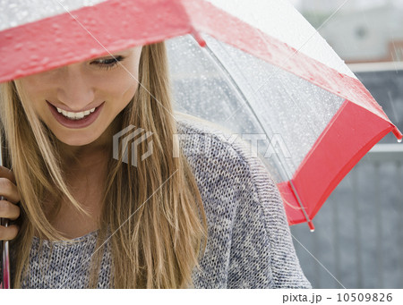 Smiling young woman with umbrella in rain 10509826