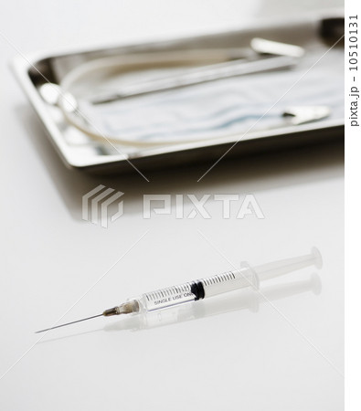 Syringe beside tray of medical supplies Syringe beside tray of medical supplies 10510131