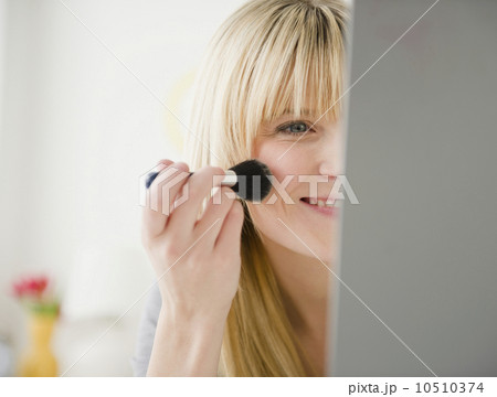 USA, New Jersey, Jersey City, young woman applying blush 10510374