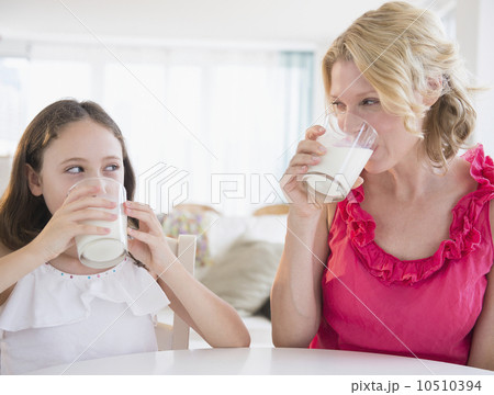 Mother and daughter (8-9 years) drinking milk 10510394
