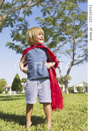 Boy (4-5) running in cape 10510451