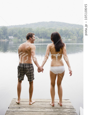 USA, New York, Putnam Valley, Roaring Brook Lake, Couple standing on pier by lake 10510645