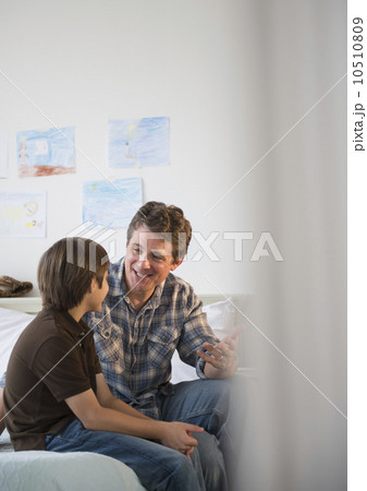 Father and son (8-9) talking 10510809