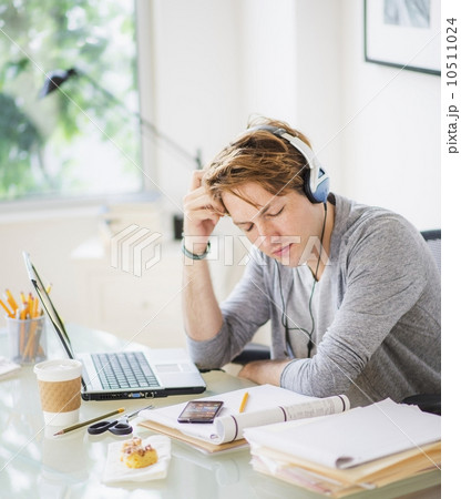Man listening to music in home office 10511024