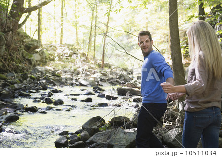 Couple walking by stream in forest 10511034