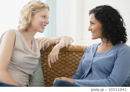 Female friends sitting on sofa and talking Female friends sitting on sofa and talking 10511041