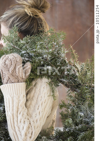 Woman carrying Christmas wreath 10511254