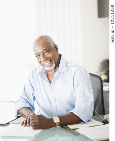 Portrait of senior man writing in office 10511308